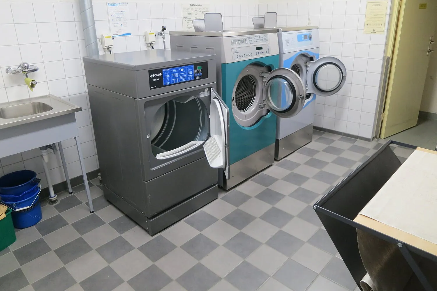 Washing machines and a sink in a communal laundry room